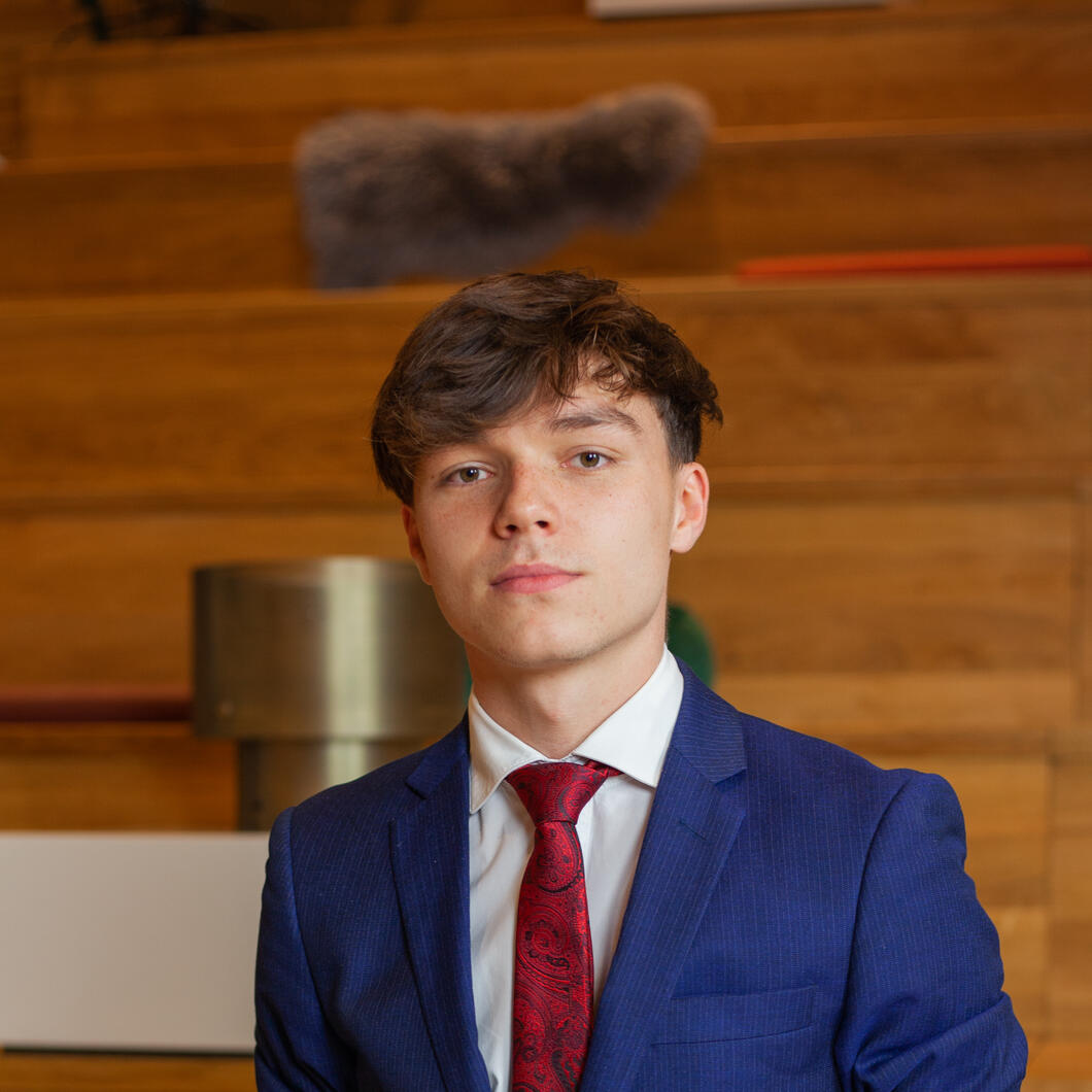 Sylvain Woest in blauw pak met rode stropdas. 