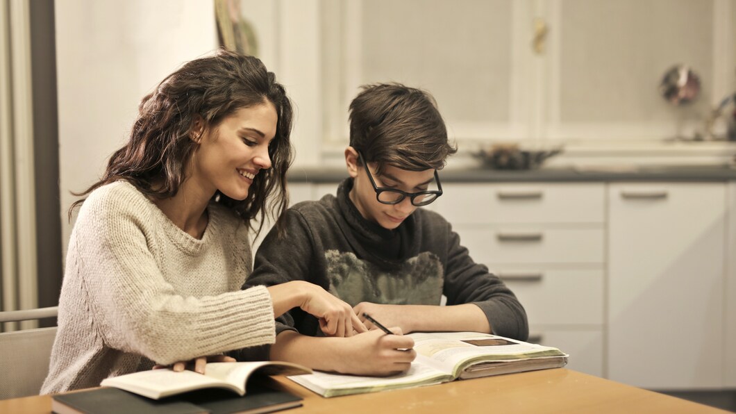 Moeder en zoon zijn samen bezig met huiswerk. 