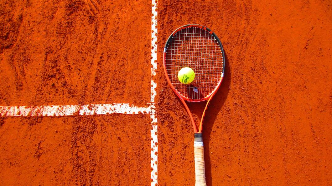 Tennisracket met tennisbal op tennisveld.