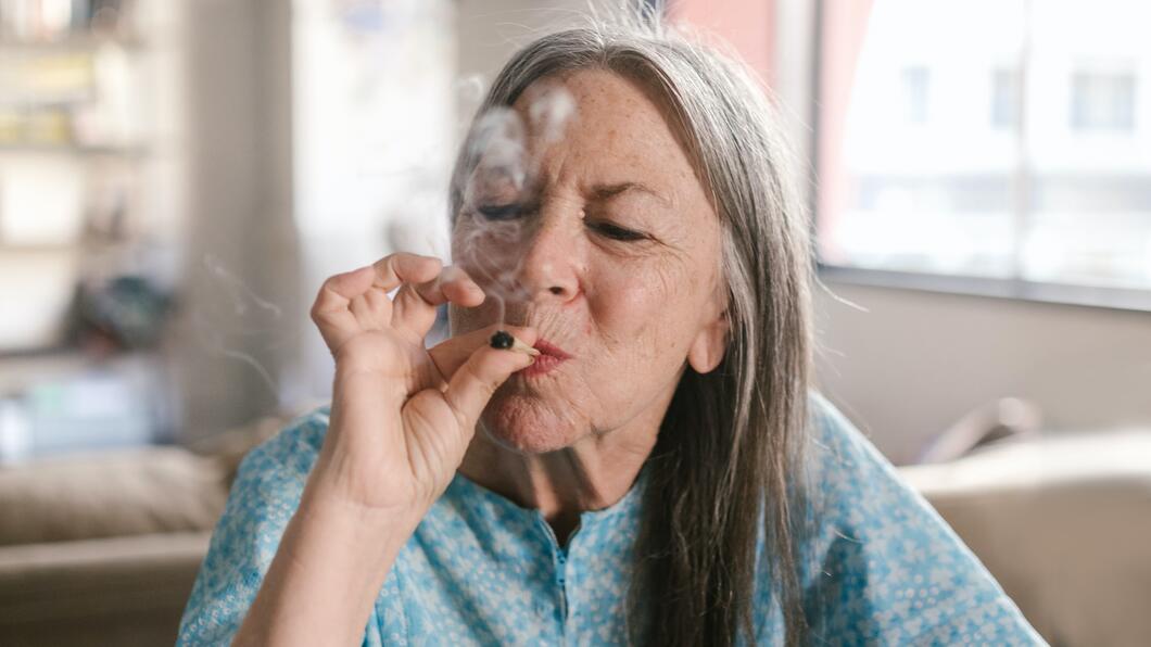Oude vrouw die een joint rookt. 