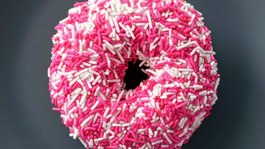 Donut met roze en witte sprinklers.