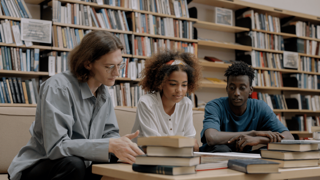 Drie mensen die aan het lezen zijn in de bibliotheek