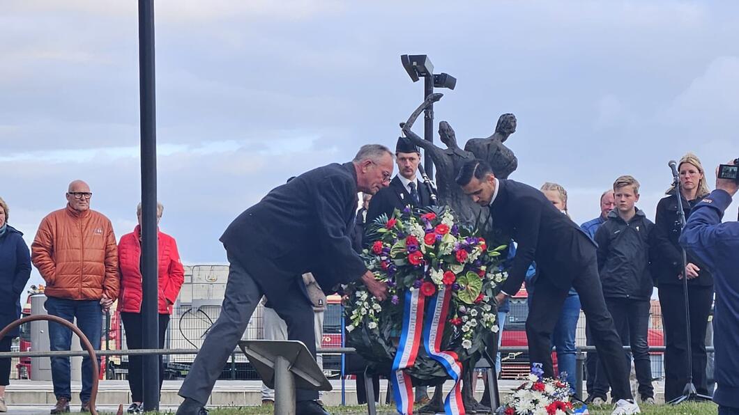 Roshano legt samen met Henk een krans bij het monument