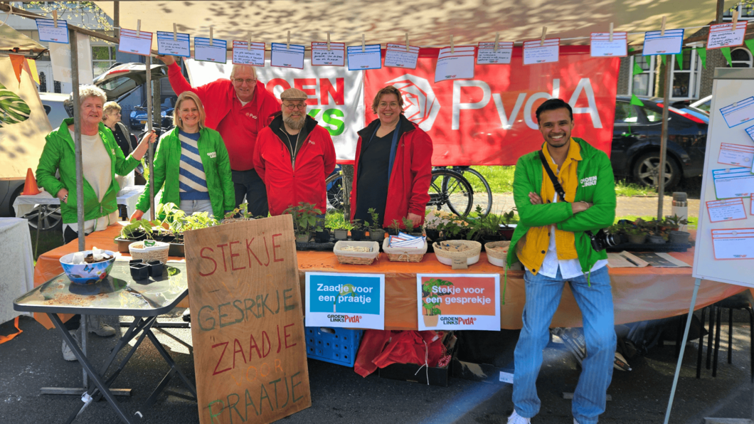 Vrijwilligers van GroenLinks-PvdA voor de kraam met 'Stekje voor een gesprekje'