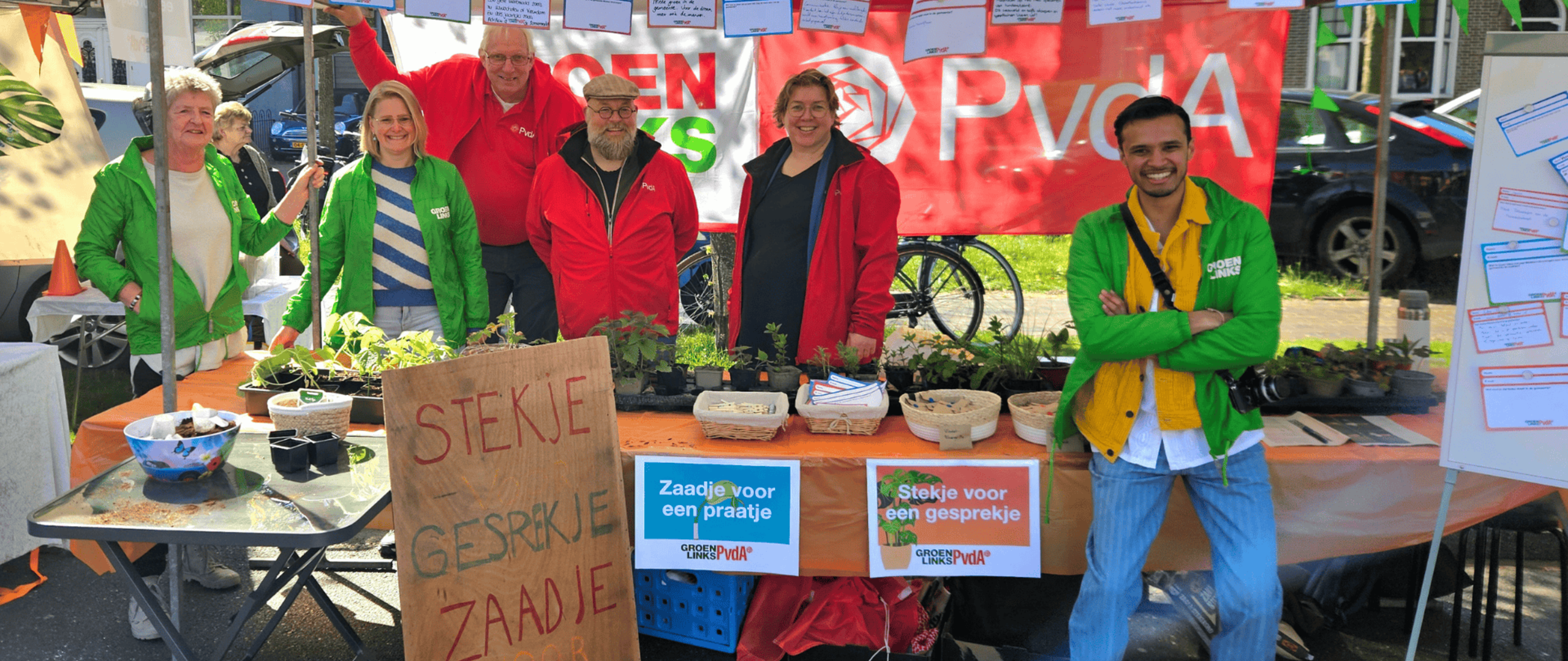 Vrijwilligers van GroenLinks-PvdA voor de kraam met 'Stekje voor een gesprekje'