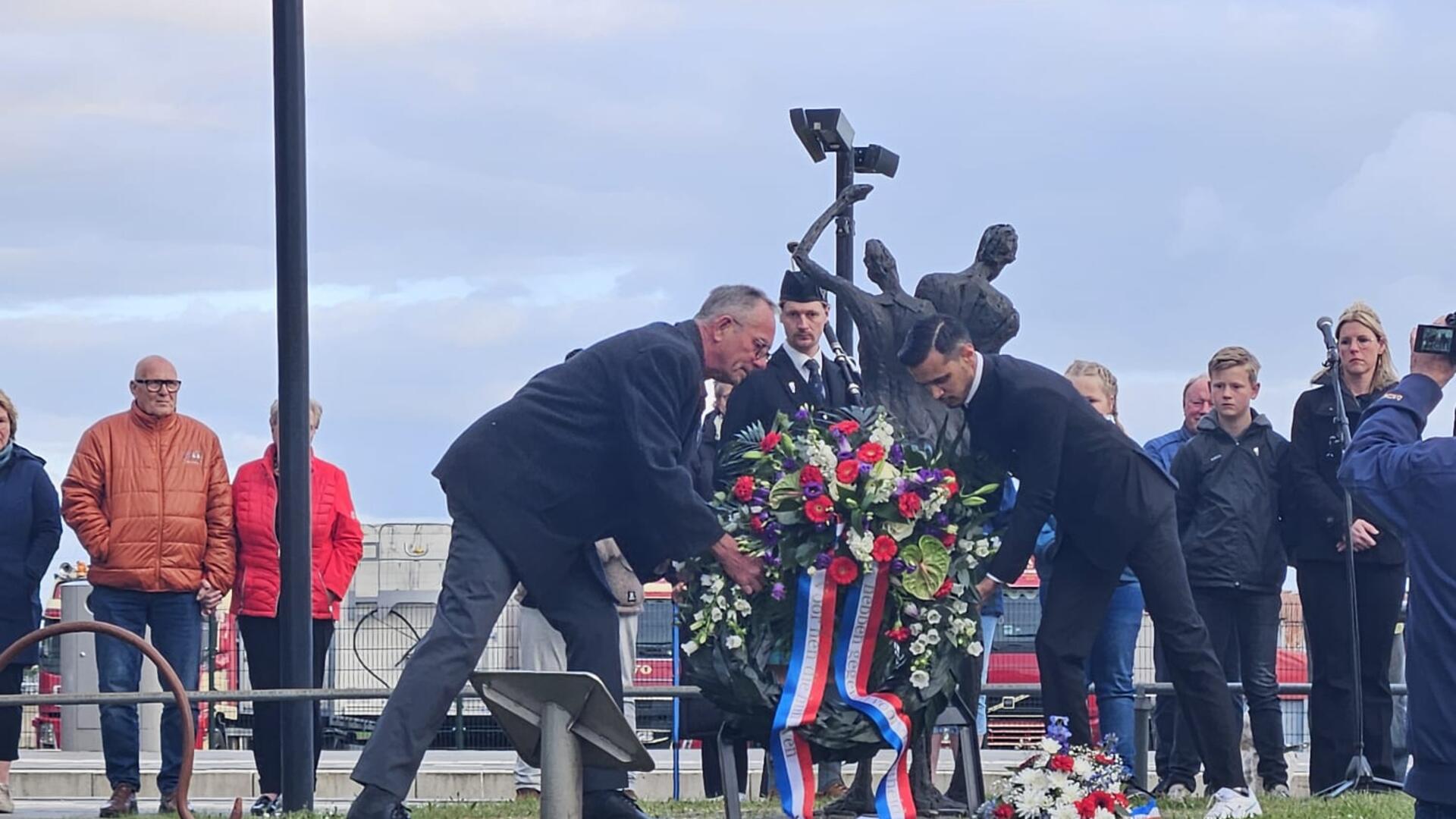 Roshano legt samen met Henk een krans bij het monument